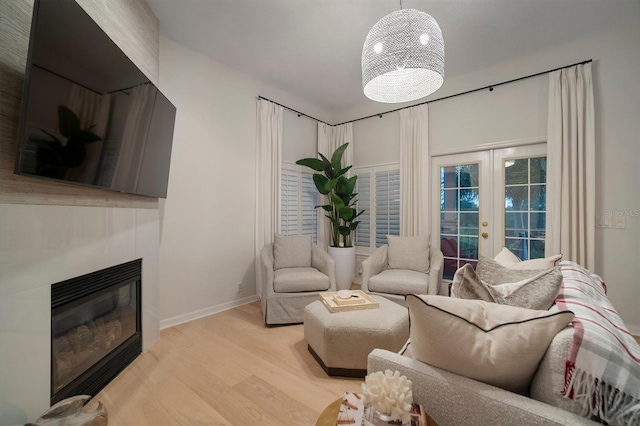 living room with wood-type flooring, a notable chandelier, and french doors