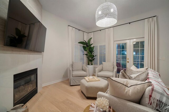 825 Islebay Dr, Apollo Beach, FL 33572 - living area featuring baseboards, light wood-style flooring, french doors, and a glass covered fireplace