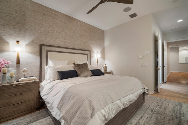 825 Islebay Dr, Apollo Beach, FL 33572 - bedroom featuring visible vents, baseboards, wallpapered walls, light wood-style floors, and an accent wall