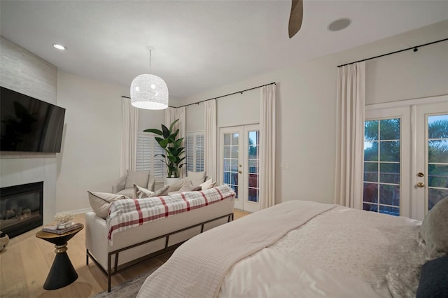 bedroom featuring a fireplace, french doors, access to outside, and dark hardwood / wood-style floors