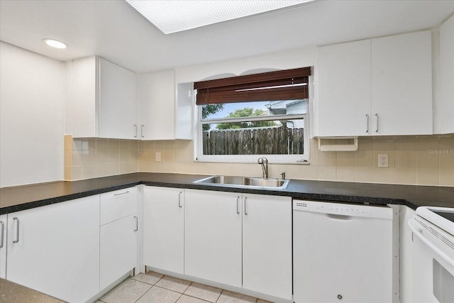 kitchen with light tile patterned floors, tasteful backsplash, white cabinets, dishwasher, and a sink