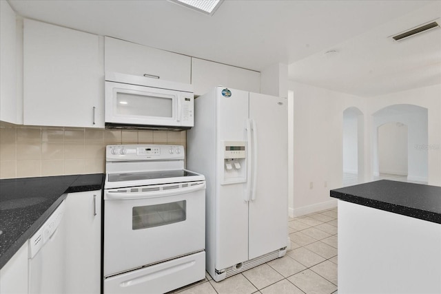 kitchen featuring white appliances, tasteful backsplash, light tile patterned floors, visible vents, and white cabinetry