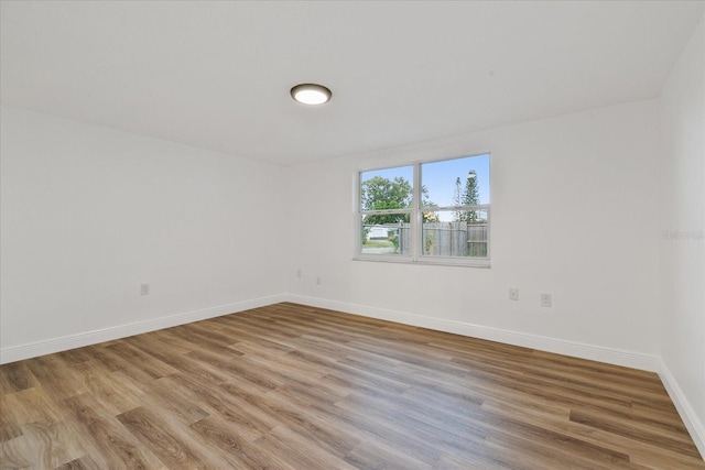 empty room featuring baseboards and wood finished floors