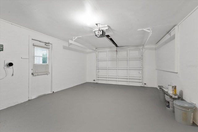 garage featuring concrete block wall and a garage door opener