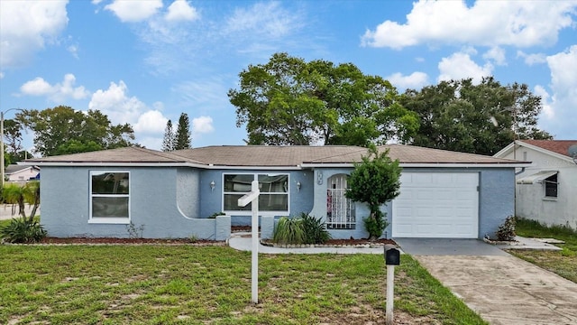 ranch-style house featuring an attached garage, a front lawn, concrete driveway, and stucco siding