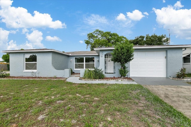 view of front facade featuring a garage, driveway, a front lawn, and stucco siding