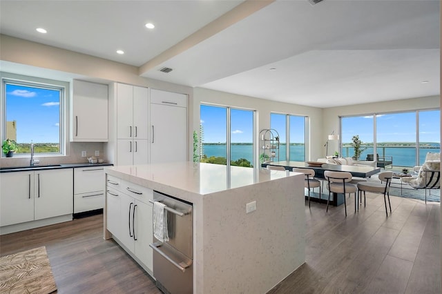 kitchen featuring a water view, a kitchen island, a healthy amount of sunlight, and white cabinetry