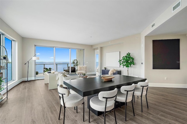 dining space featuring a water view and wood-type flooring