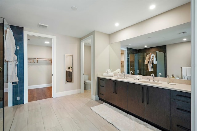 bathroom featuring vanity, toilet, and an enclosed shower