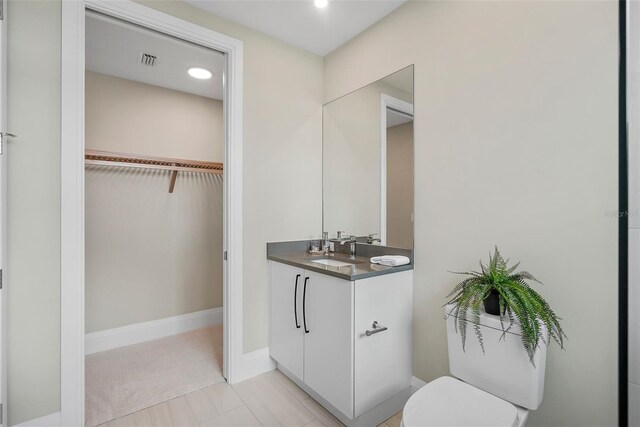 bathroom with vanity, toilet, and tile patterned floors