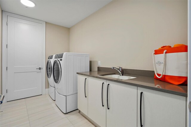 washroom featuring light tile patterned floors, cabinets, independent washer and dryer, and sink