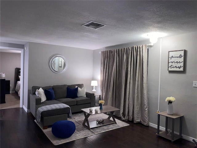 living room featuring a textured ceiling and dark hardwood / wood-style floors