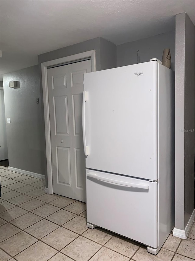 6115 7th Ave, New Port Richey, FL 34653 - kitchen with freestanding refrigerator, light tile patterned flooring, and baseboards