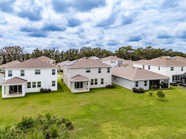 back of property with a yard and a sunroom