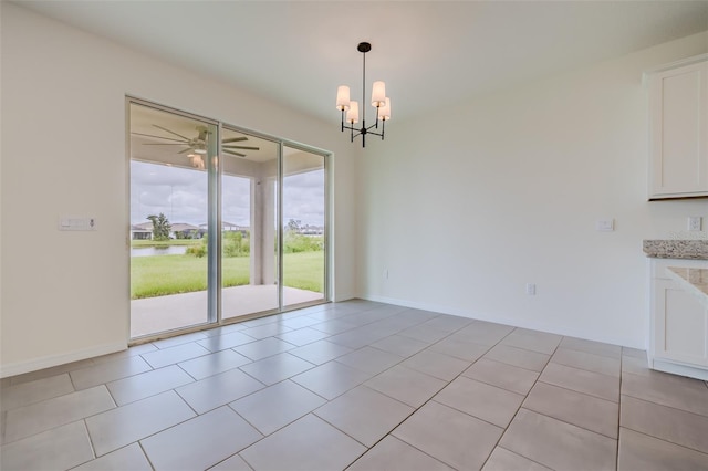 unfurnished dining area with ceiling fan with notable chandelier and light tile patterned flooring