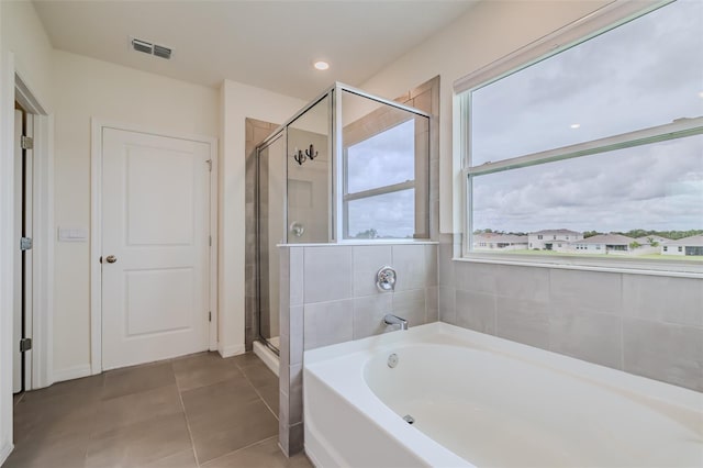 bathroom with independent shower and bath and tile patterned floors