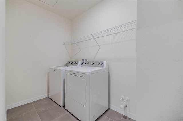 laundry area featuring washing machine and dryer and light tile patterned floors