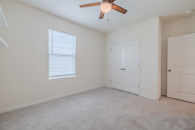 unfurnished bedroom with a closet, ceiling fan, and light carpet