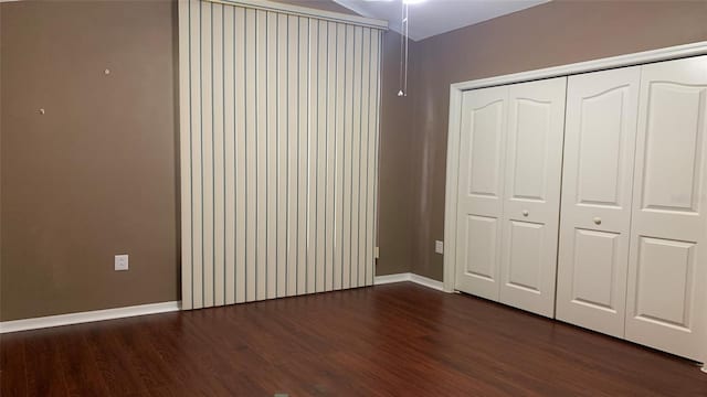 unfurnished bedroom featuring a closet and dark hardwood / wood-style flooring