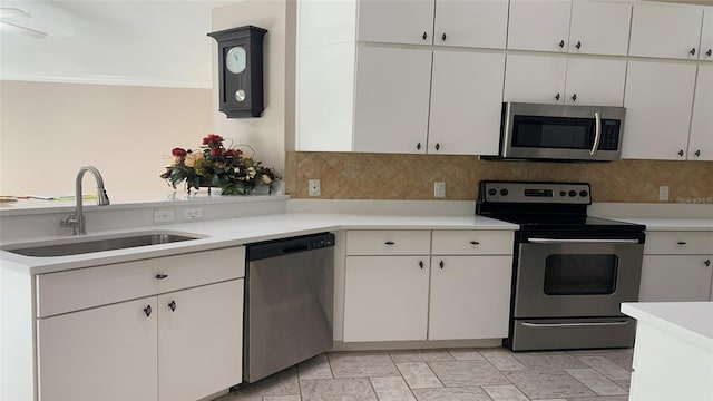 kitchen with backsplash, crown molding, appliances with stainless steel finishes, white cabinetry, and sink