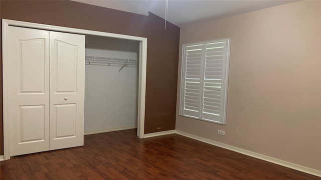 unfurnished bedroom with a closet and dark hardwood / wood-style flooring