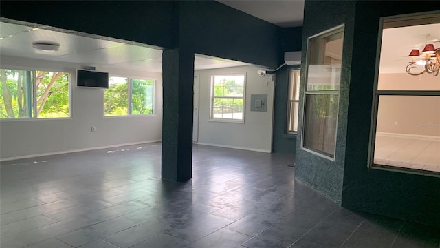 spare room featuring dark tile patterned flooring and electric panel