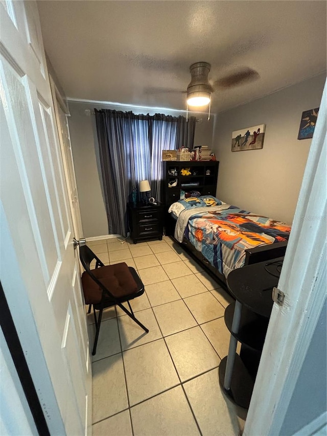 tiled bedroom featuring ceiling fan and a textured ceiling