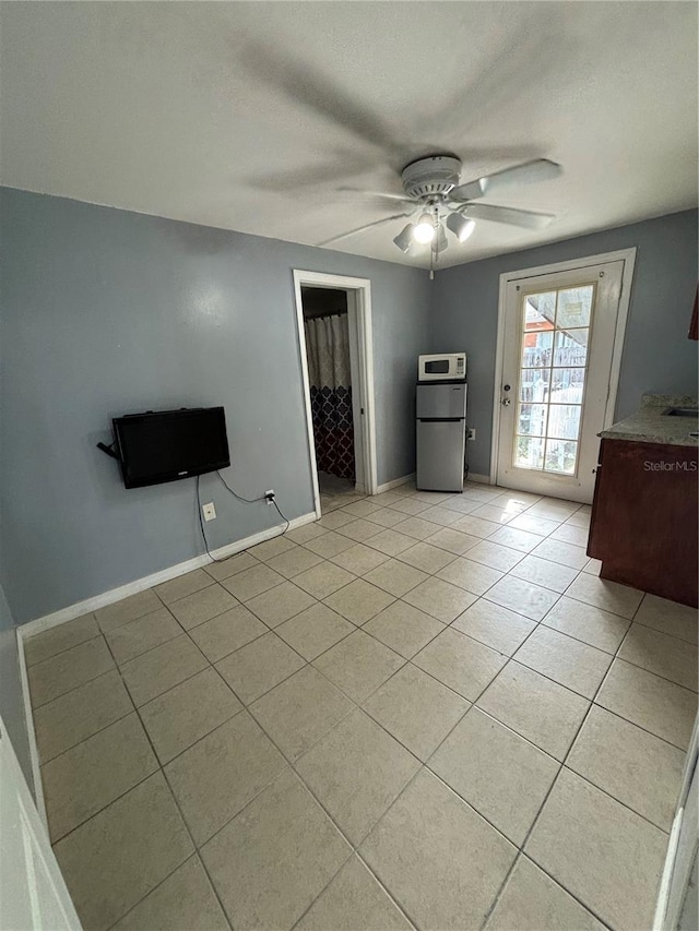 unfurnished bedroom with ceiling fan, light tile patterned floors, and a spacious closet