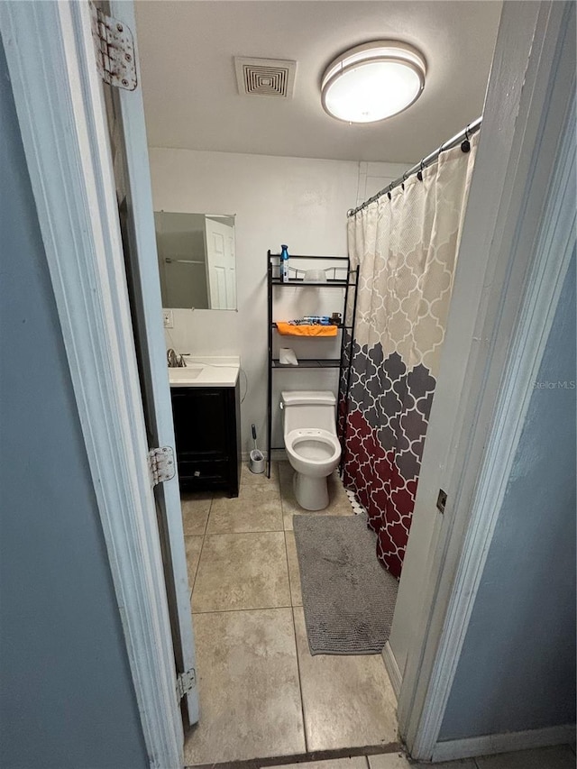 bathroom with tile patterned flooring, toilet, and vanity