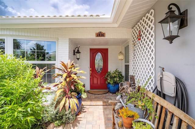 entrance to property with brick siding and a porch