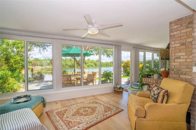 living room with a water view, ceiling fan, and hardwood / wood-style flooring