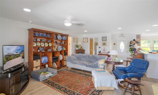 living room with ceiling fan and light hardwood / wood-style flooring