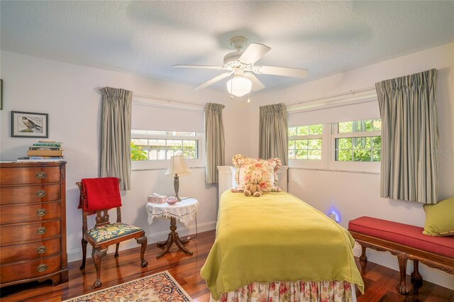 bedroom featuring multiple windows, ceiling fan, hardwood / wood-style floors, and a textured ceiling