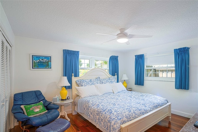 bedroom with a ceiling fan, a textured ceiling, wood finished floors, a closet, and baseboards