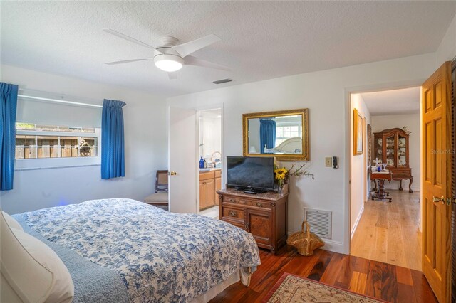 bedroom featuring a textured ceiling, dark wood-type flooring, ceiling fan, and ensuite bathroom