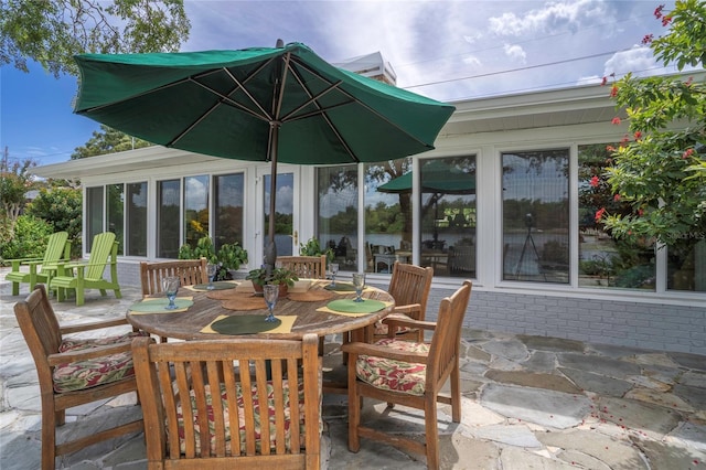 view of patio / terrace featuring outdoor dining space and a sunroom