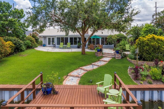 back of property featuring a wooden deck, a yard, and a patio area