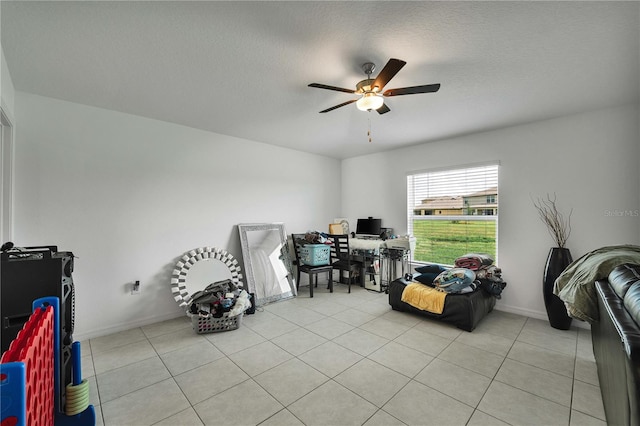 misc room with ceiling fan, a textured ceiling, and light tile patterned floors