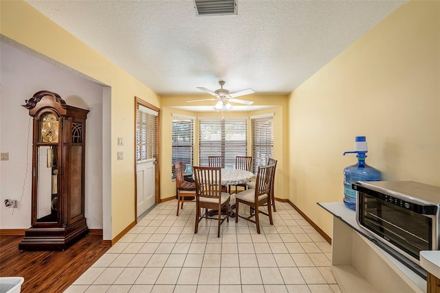 tiled dining space featuring ceiling fan and a textured ceiling