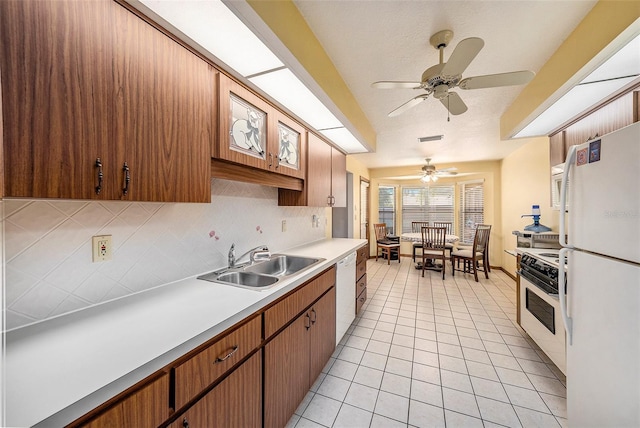 kitchen featuring ceiling fan, sink, white appliances, decorative backsplash, and light tile patterned floors