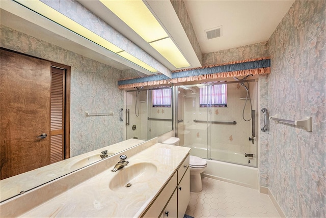 full bathroom featuring tile patterned floors, vanity, toilet, and enclosed tub / shower combo