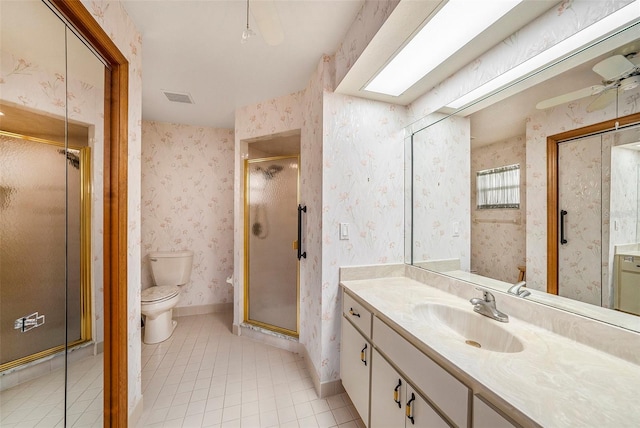 bathroom featuring vanity, a shower with door, tile patterned floors, ceiling fan, and toilet