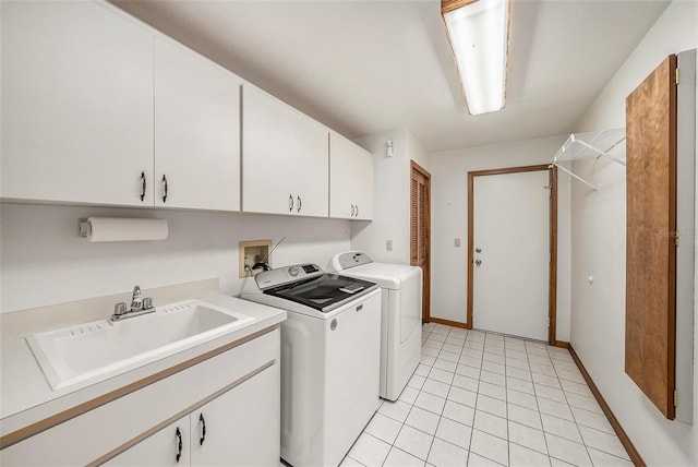 clothes washing area featuring cabinets, light tile patterned floors, washing machine and clothes dryer, and sink