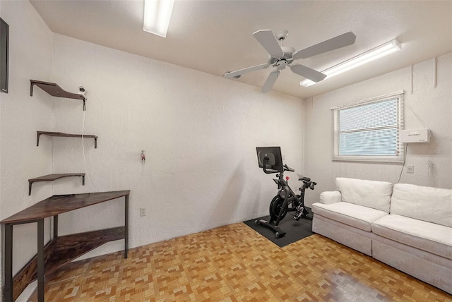 workout room featuring ceiling fan and light parquet flooring