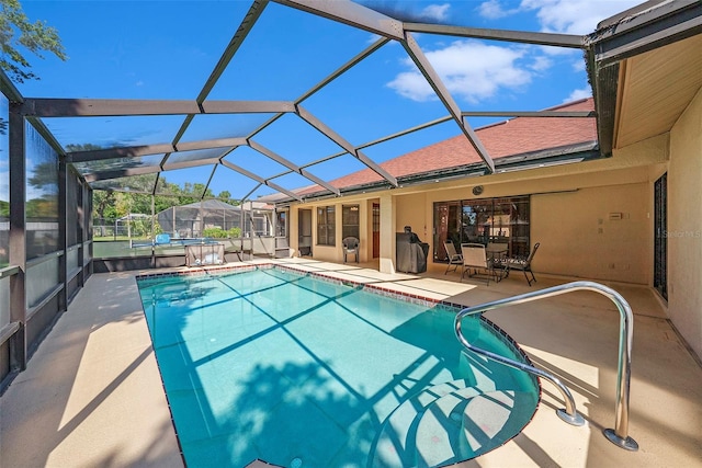 view of swimming pool featuring a patio and a lanai