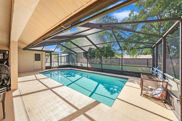 view of swimming pool with a patio and a lanai