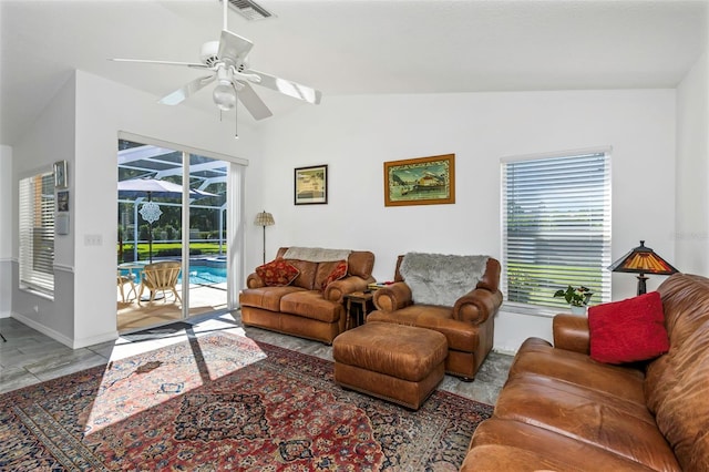 living room featuring ceiling fan, a healthy amount of sunlight, and lofted ceiling