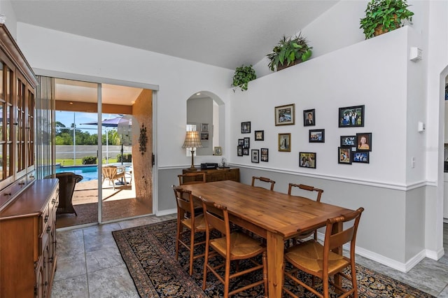 dining room featuring lofted ceiling and a textured ceiling