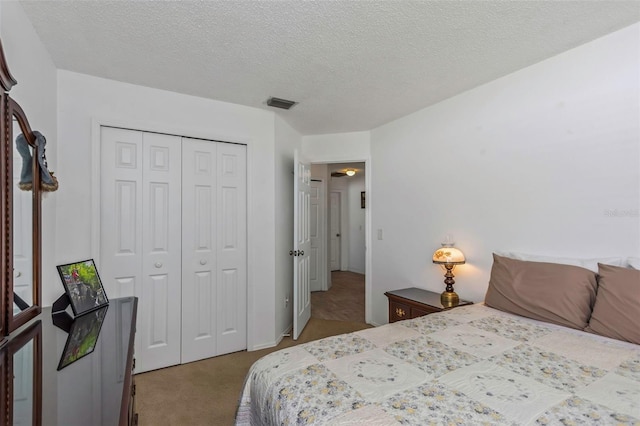 carpeted bedroom with a closet and a textured ceiling