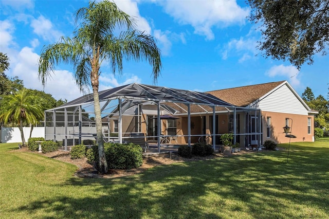 rear view of house featuring a yard and a lanai